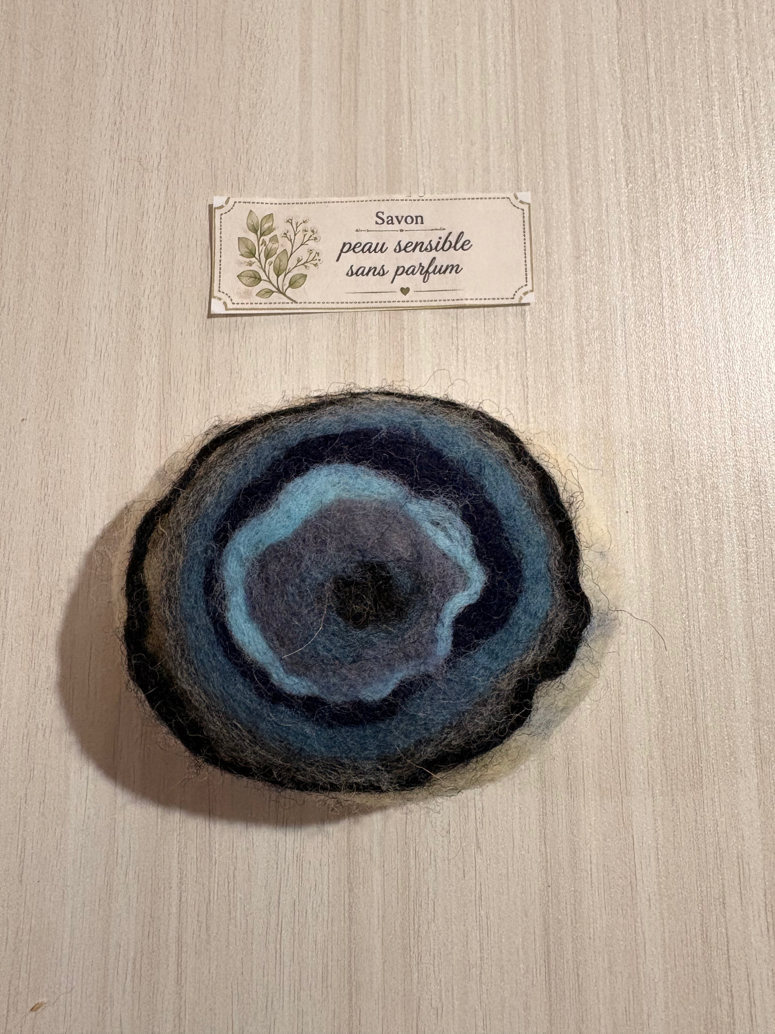 Savon feutré artisanal Nuit boréale pour peau sensible, sans parfum, en laine naturelle aux teintes bleues et noires.